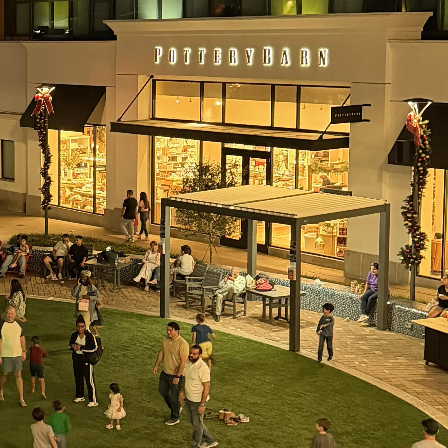 At night, the modern motorized pergola complements the plaza beautifully