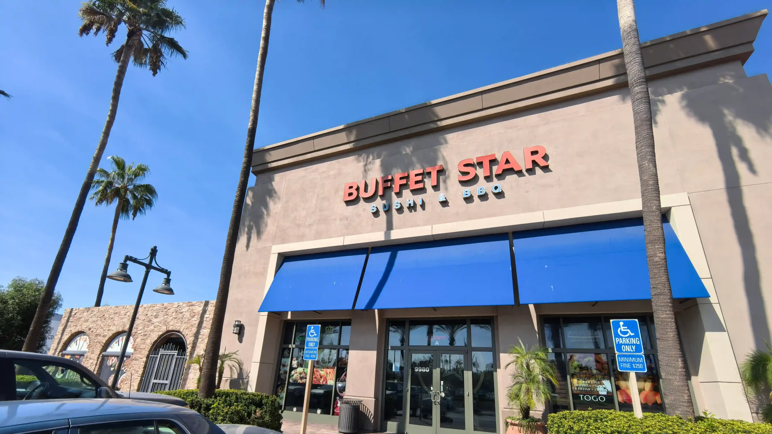 Exterior of "Buffet Star" restaurant in a strip mall, with parking lot and palm trees.