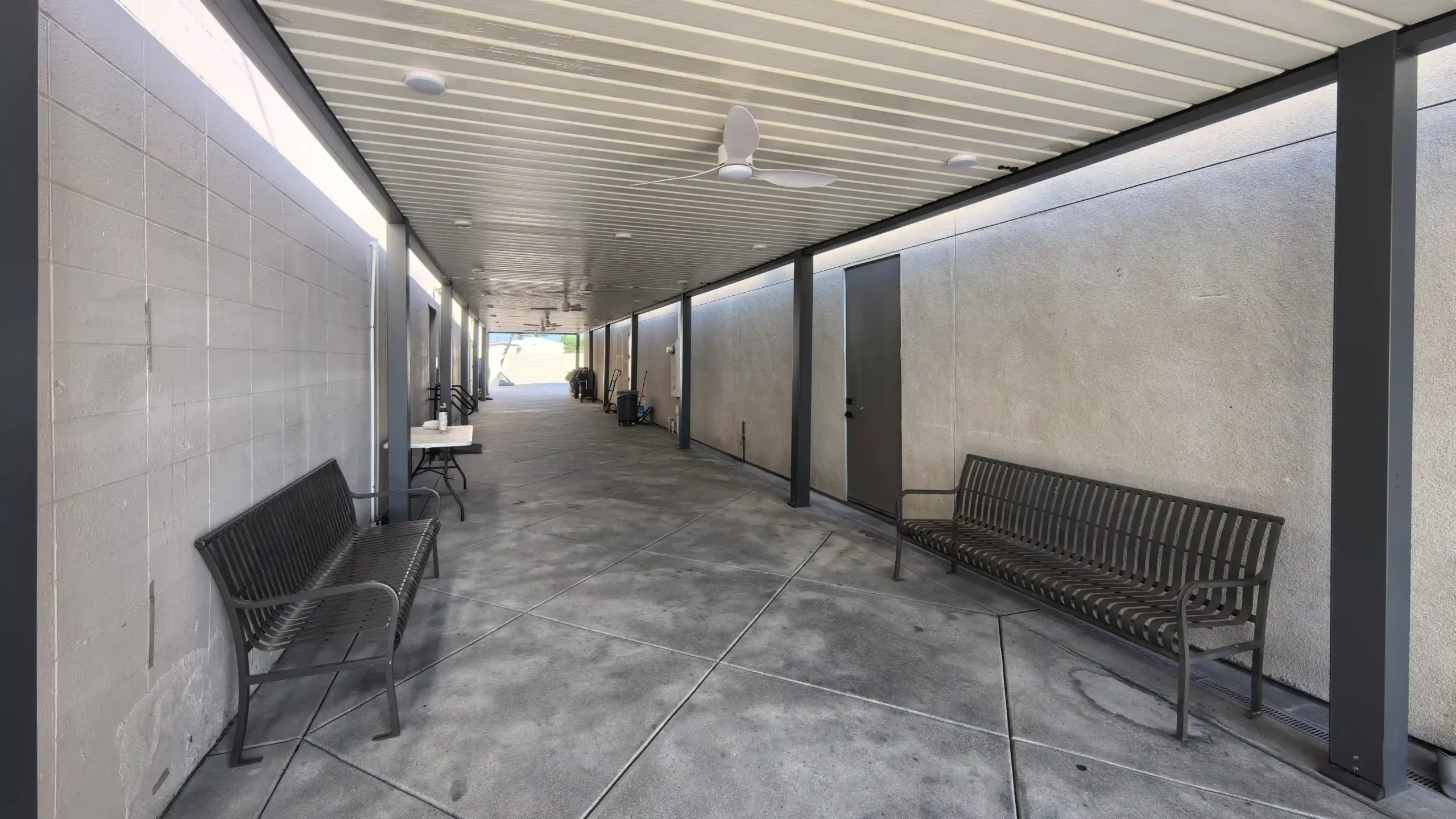 Covered outdoor corridor: Sheltered, functional walkway with seating