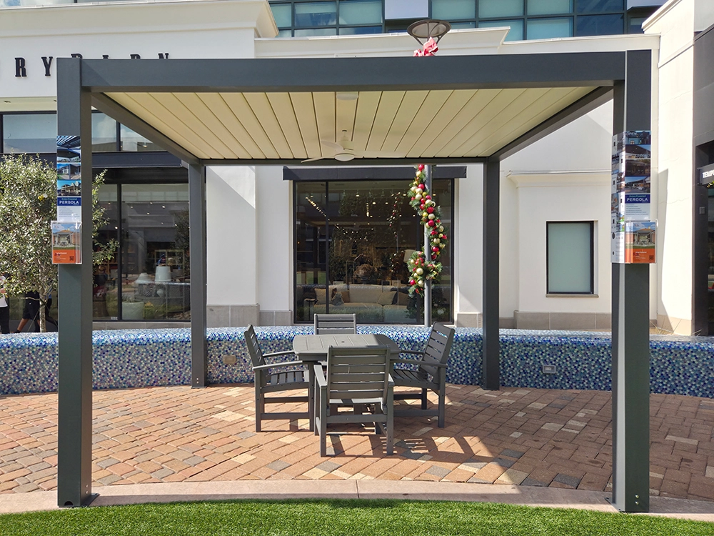 The outdoor awning at Woodlands Mall covers a set of gray wooden dining tables and chairs