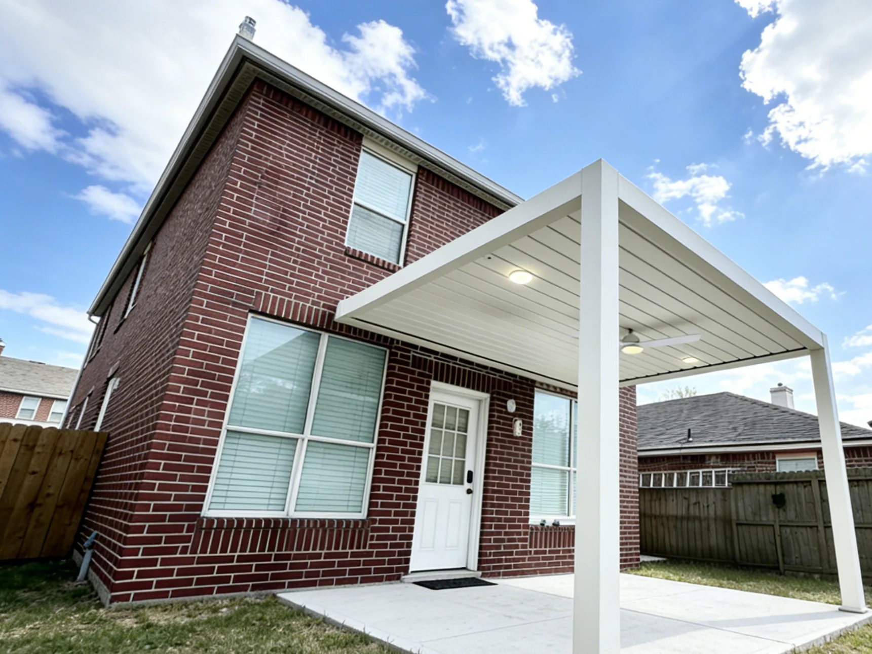 side angle of wall-attached louvered pergola enhancing home curb appeal