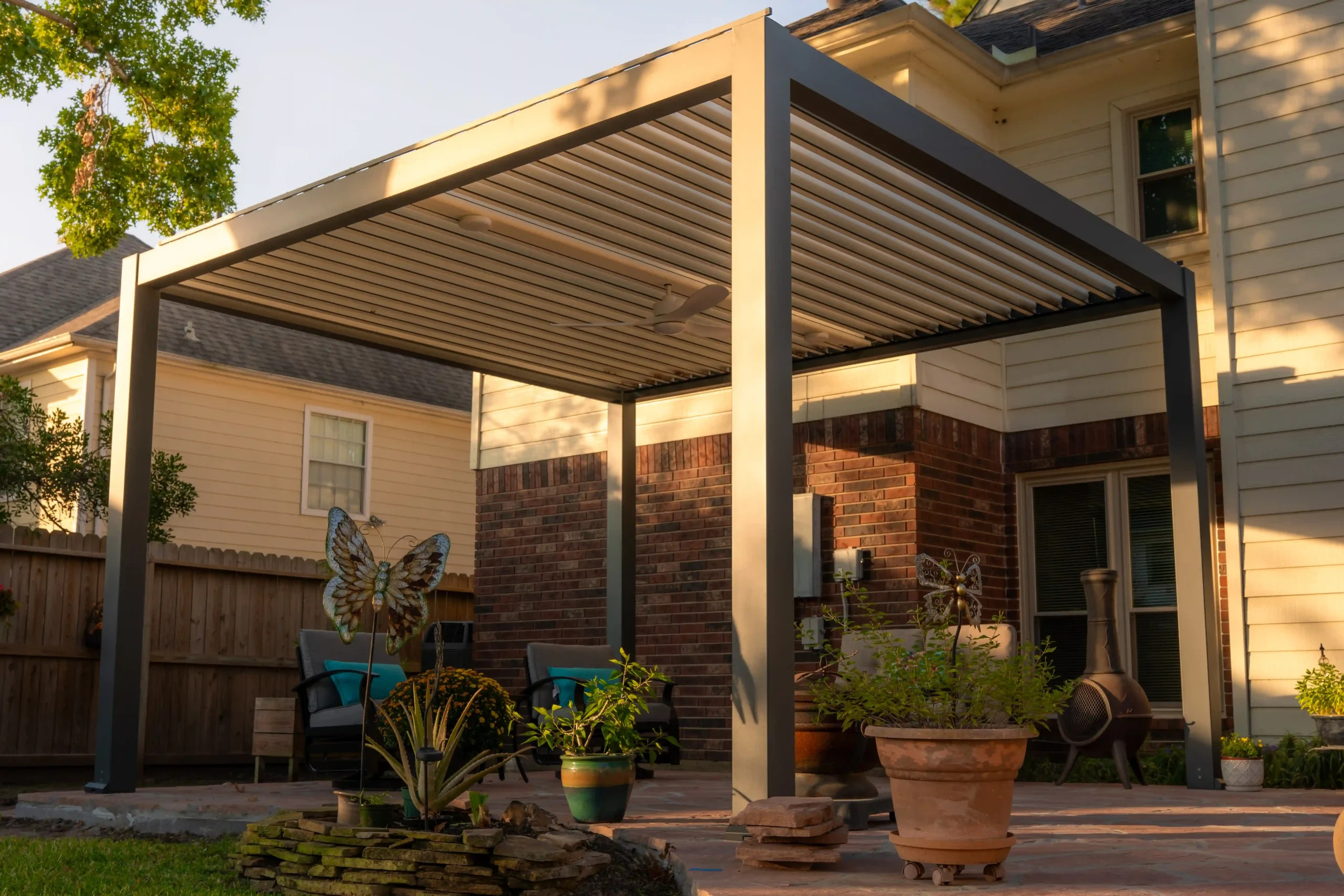 Gray frame motorized Louvered pergola with white louvers at golden hour