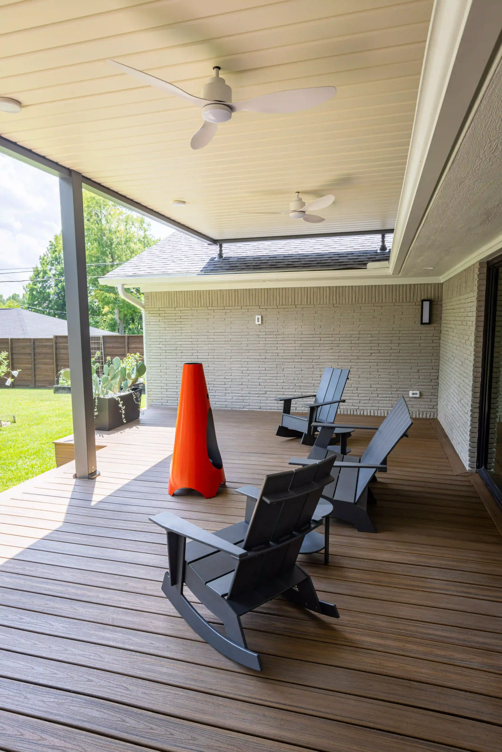 Interior view of roof-mounted louvered pergola with outdoor seating and ceiling fans