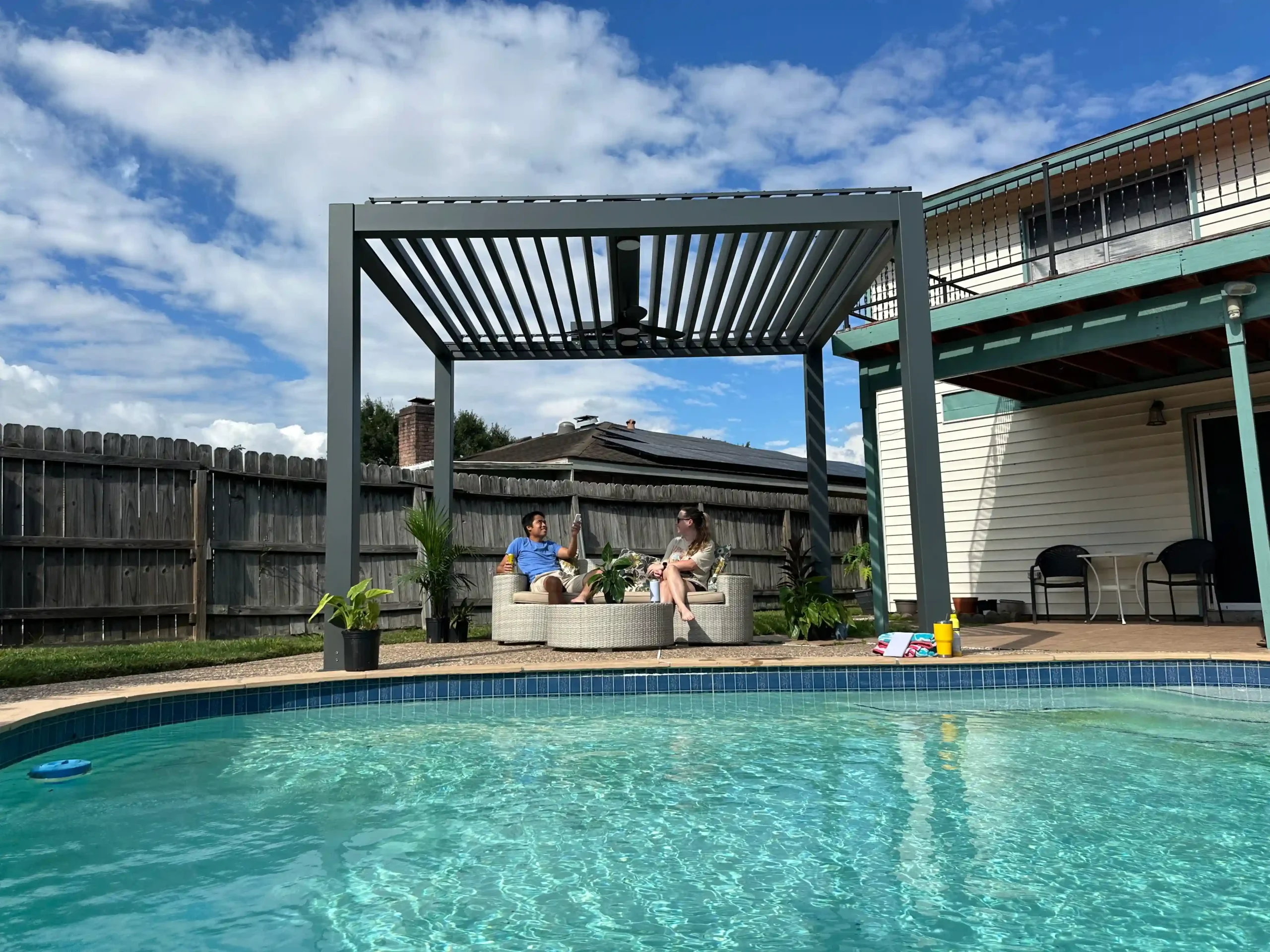 Modern solar pergola with roof installed by a residential swimming pool