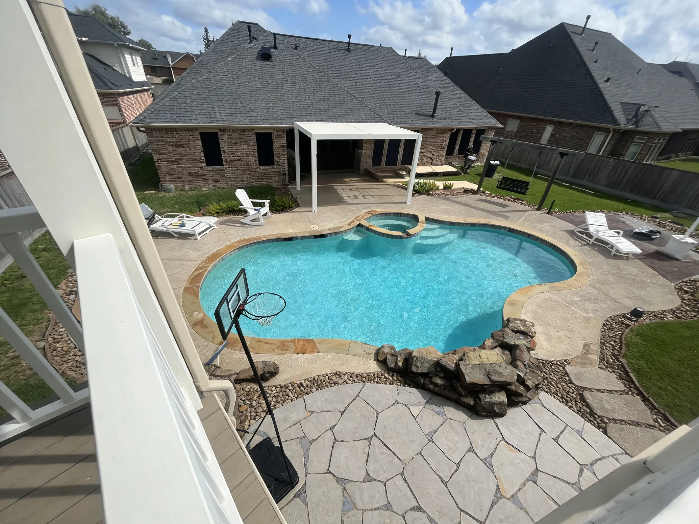 aerial view of residential swimming pool with louvered pergola