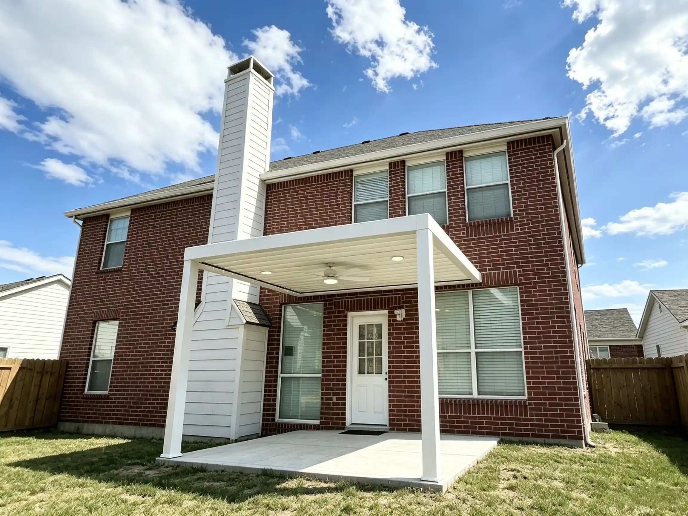 White louver‑roof pergola outside red‑brick home entrance